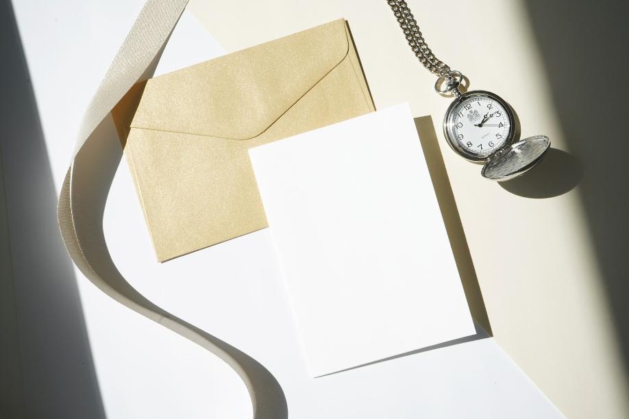 silver round analog watch on white paper